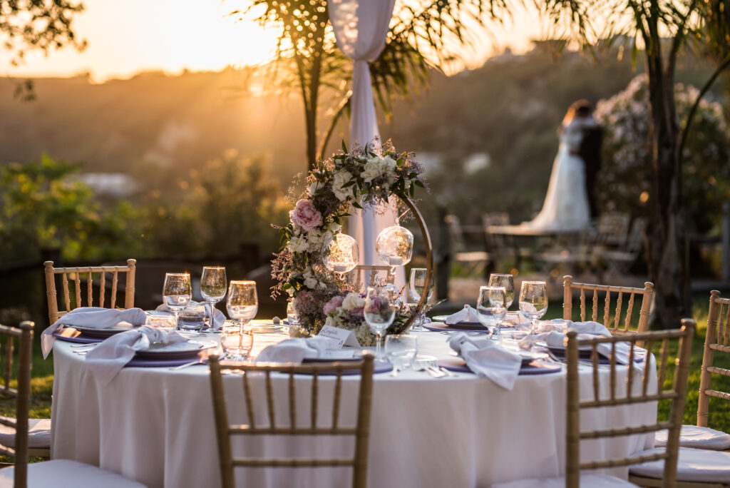 How to Incorporate Southern Charm Into Your Wedding at Hummingbird Hill 1 Southern wedding reception with farmhouse tables, elegant floral centerpieces, and outdoor lights at sunset