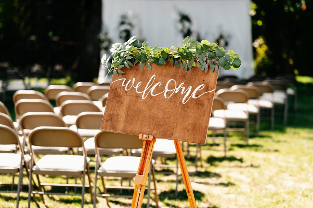 How to Personalize Your Wedding at Hummingbird Hill: Décor, Themes, and More 1 Personalized wedding décor inside a rustic-elegant reception hall with candles, flowers, and custom signage
