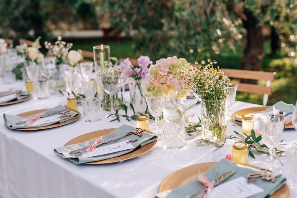 Intimate wedding dinner with farmhouse tables, candles, and greenery at a rustic elegant venue
